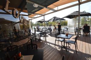 a restaurant with tables and chairs on a deck at Benalla Apartments in Benalla