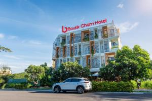 een witte auto geparkeerd voor een gebouw bij Boutik Cham NhaTrang Hotel in Nha Trang