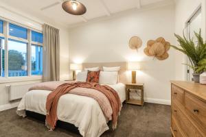 - une chambre avec un grand lit et une fenêtre dans l'établissement The Village Reserve Boutique Accomodation, à Auckland