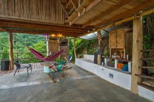 a patio with a hammock and chairs on it at Elemental lodge in Santa Marta