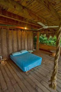 1 dormitorio con 1 cama en una habitación de madera en Elemental lodge en Santa Marta