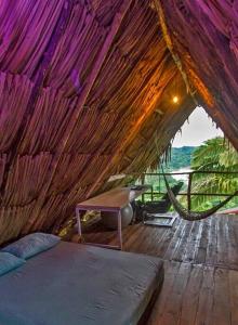 een kamer met een bed en een hangmat bij Elemental lodge in Santa Marta