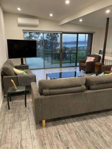 a living room with two couches and a tv at Family Beach Home Dromana in Dromana