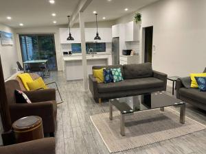 a living room with two couches and a kitchen at Family Beach Home Dromana in Dromana