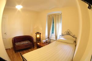 a bedroom with a bed and a chair and a window at BBQ Lodge in Camogli