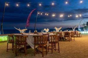 - un groupe de tables sur la plage la nuit dans l'établissement Desa Swan Villas & SPA, Keramas, à Keramas