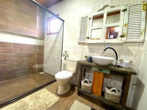 a bathroom with a toilet and a sink and a shower at CHALÉ MONTANHÊS ALPES in São Francisco de Paula