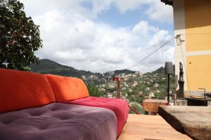 a couch sitting on a balcony with a view of a city at BBQ Lodge in Camogli