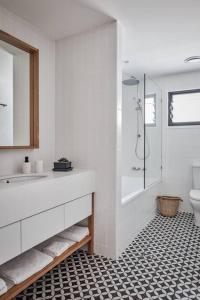 uma casa de banho com um chuveiro, um lavatório e um WC. em Sanctuary Spaces - Lomani Eleven em Byron Bay