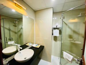 ein Bad mit einem Waschbecken und einer Dusche in der Unterkunft Kim Thai Hotel in Thái Nguyên