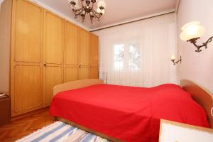- une chambre avec un lit rouge et des placards en bois dans l'établissement Apartment Viganj 633c, à Viganj
