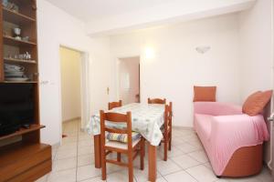 a small dining room with a table and a couch at Apartment Viganj 633c in Viganj