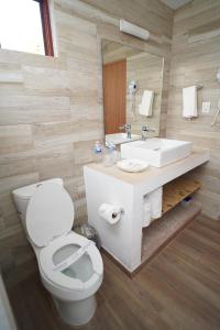 a bathroom with a white toilet and a sink at Playa Esperanza Resort in Celestino Gasca