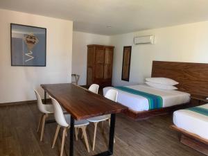 - une chambre avec 2 lits et une table et des chaises en bois dans l'établissement Playa Esperanza Resort, à Celestino Gasca