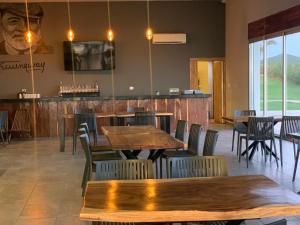 un restaurant avec des tables et des chaises en bois ainsi qu'un bar dans l'établissement Playa Esperanza Resort, à Celestino Gasca