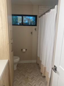 a bathroom with a toilet and a white shower curtain at South Montezuma Properties LLC in Prescott
