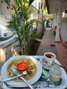 a table with a plate of food and a cup of coffee at H.Said Homestay in Gili Trawangan