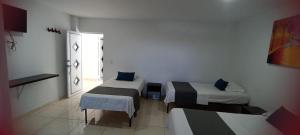 een kamer met 2 bedden en een raam bij Hotel La Inmaculada in Soledad