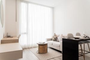 a white living room with a white couch and a table at Bo Living 81 in Bogotá