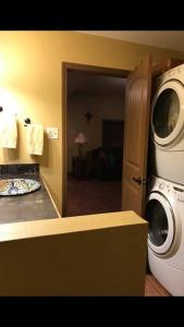 uma cozinha com uma máquina de lavar roupa e um micro-ondas em La Maison du Bayou Petite Anse em New Iberia