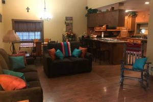 新伊比利亚La Maison du Bayou Petite Anse near Avery Island的客厅里有一张沙发和一个厨房