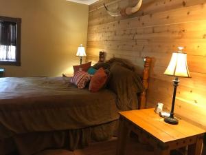 新伊比利亚La Maison du Bayou Petite Anse near Avery Island的带床和木墙的卧室