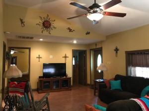 新伊比利亚La Maison du Bayou Petite Anse near Avery Island的客厅配有吊扇和平面电视。