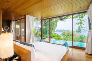 a bedroom with a bed and a large window at SYLVAN Koh Chang in Ko Chang