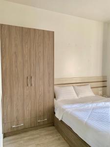 Schlafzimmer mit einem Bett und einem Holzschrank in der Unterkunft Hotel GreenRiver in Ho-Chi-Minh-Stadt