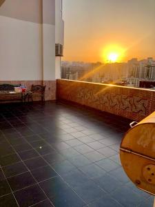 10 out of 10 VIP Sea view apartment with terrace في باكو: شرفة مبنى مع غروب الشمس في الخلفية