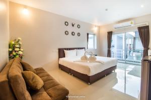 1 dormitorio con 1 cama y 1 sofá en Makan Resort en Kanchanaburi