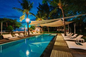 una piscina con sillas y una hamaca junto a un complejo en Gili Eco Villas, en Gili Trawangan