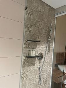 a shower in a bathroom with a tile wall at Apec 5 sao TP.Tuy Hòa - View biển và view hồ bơi in Ðông Tác (1)
