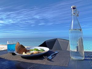 a table with a plate of food and a bottle of water at Niru Isle Maldives in Gaafaru +70 photos