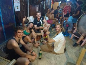 a group of people sitting in a bar with drinks at sunny in town in Pai