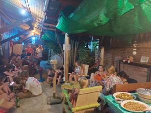 a group of people sitting in a room with food at sunny in town in Pai