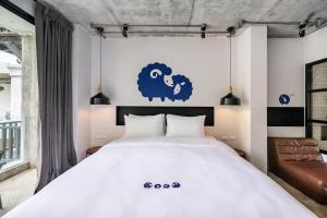 a bedroom with a bed with a blue sheep on the wall at Kokotel Khao Lak Lighthouse in Khao Lak