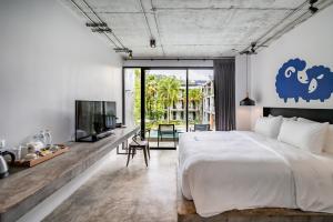 a bedroom with a large bed and a tv at Kokotel Khao Lak Lighthouse in Khao Lak