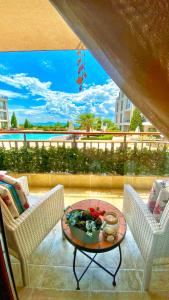 a patio with two chairs and a table on a balcony at DIAMOND APARTMENT №1 - RELAX HOLIDAY VIEWS SEA AND POOL in Burgas City