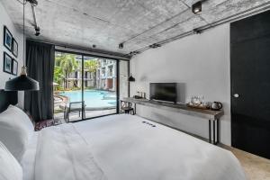a bedroom with a large white bed and a tv at Kokotel Khao Lak Lighthouse in Khao Lak