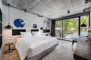 a bedroom with a large bed and a pool at Kokotel Khao Lak Lighthouse in Khao Lak