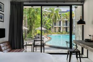 um quarto de hotel com vista para uma piscina em Kokotel Khao Lak Lighthouse - SHA Extra Plus em Khao Lak