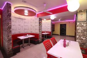 a restaurant with tables and chairs and purple lighting at Hotel O Sher E Bengal in Durgāpur