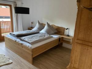 een houten bed met kussens in een slaapkamer bij TraunZeit in Siegsdorf