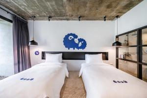 two beds in a room with a sheep sticker on the wall at Kokotel Khao Lak Lighthouse in Khao Lak