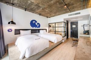 a bedroom with two beds and a table at Kokotel Khao Lak Lighthouse in Khao Lak