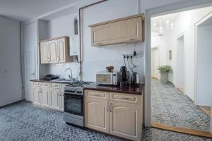 a kitchen with wooden cabinets and a stove top oven at Apartamenty Piłsudskiego in Gliwice