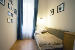 ein kleines Schlafzimmer mit einem Bett und einem Fenster in der Unterkunft Louisa Apartment in Budapest