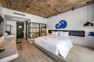 a bedroom with a large white bed with a blue sheep on the wall at Kokotel Khao Lak Lighthouse in Khao Lak