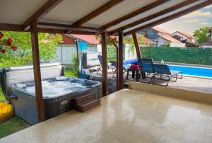 a hot tub on a patio next to a pool at Casa Gabrielle in Călimăneşti